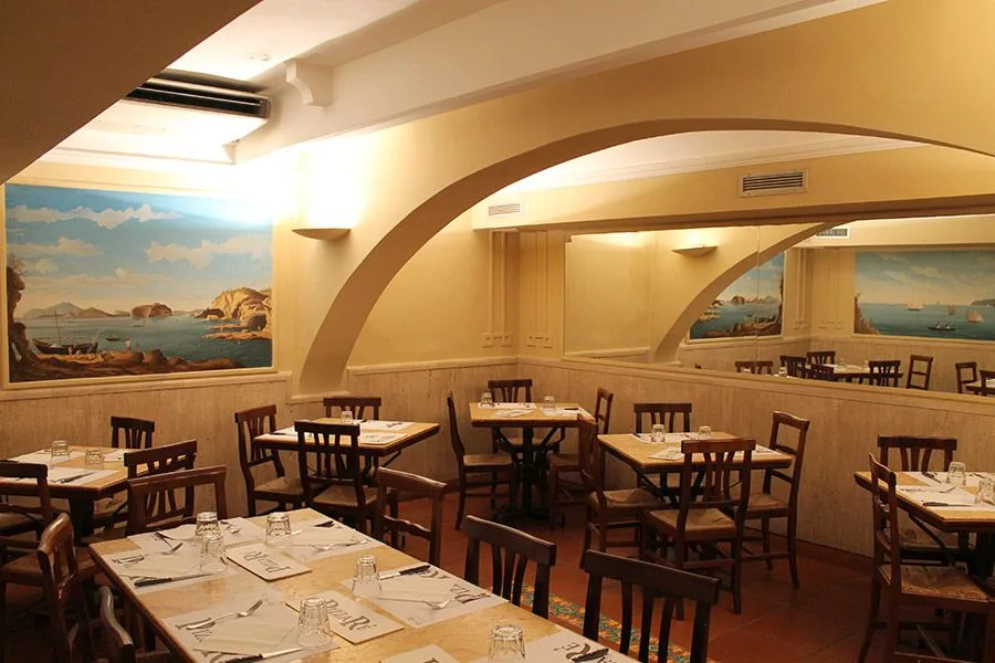 Sala di PizzaRé con archi e pareti dipinte con paesaggi di mare